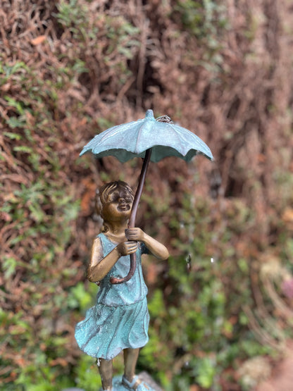 Menina de bronze sob fonte de guarda-chuva - decoração de jardim